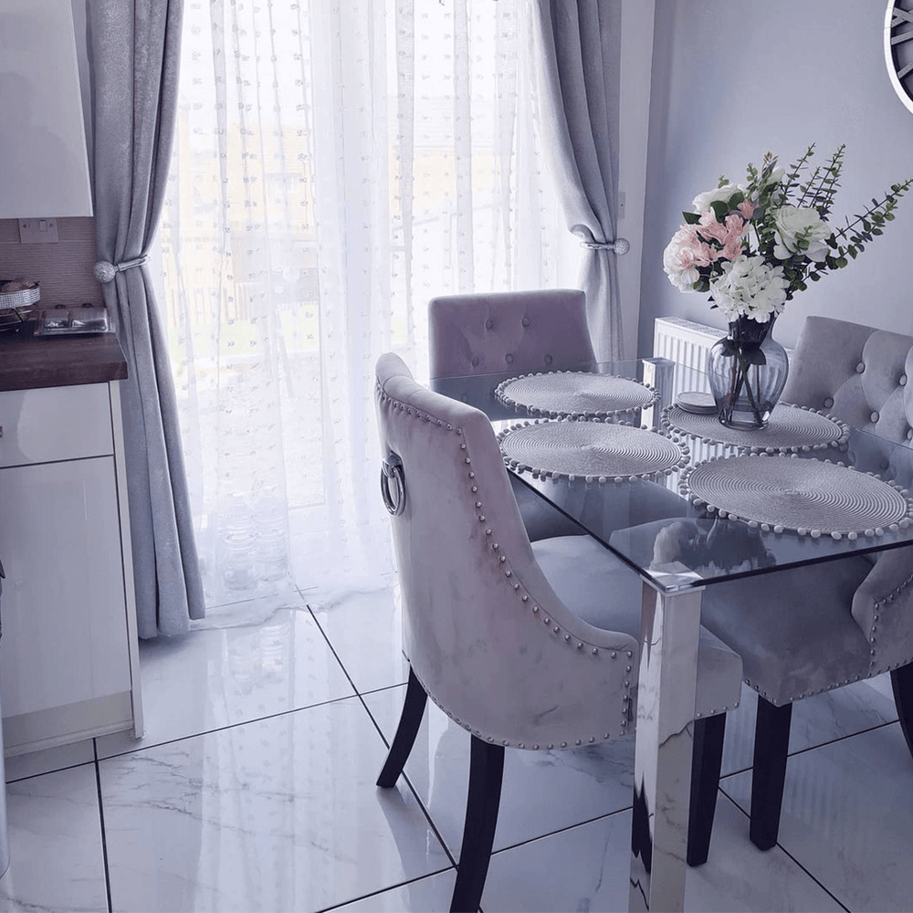 Grey Windsor LUX velvet dining chairs with ring-pull backs at a glass dining table