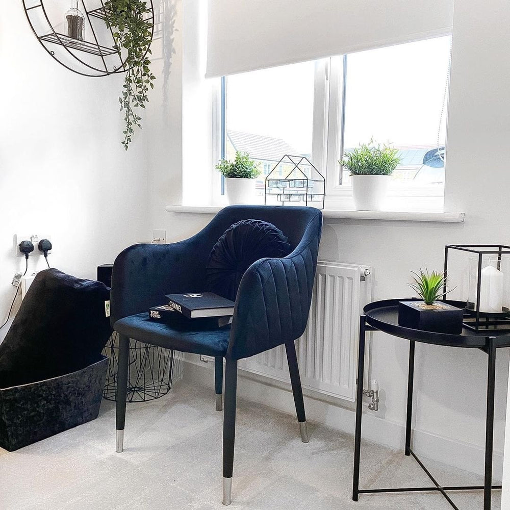 Navy Milano velvet chair beside a black side table in a bright corner