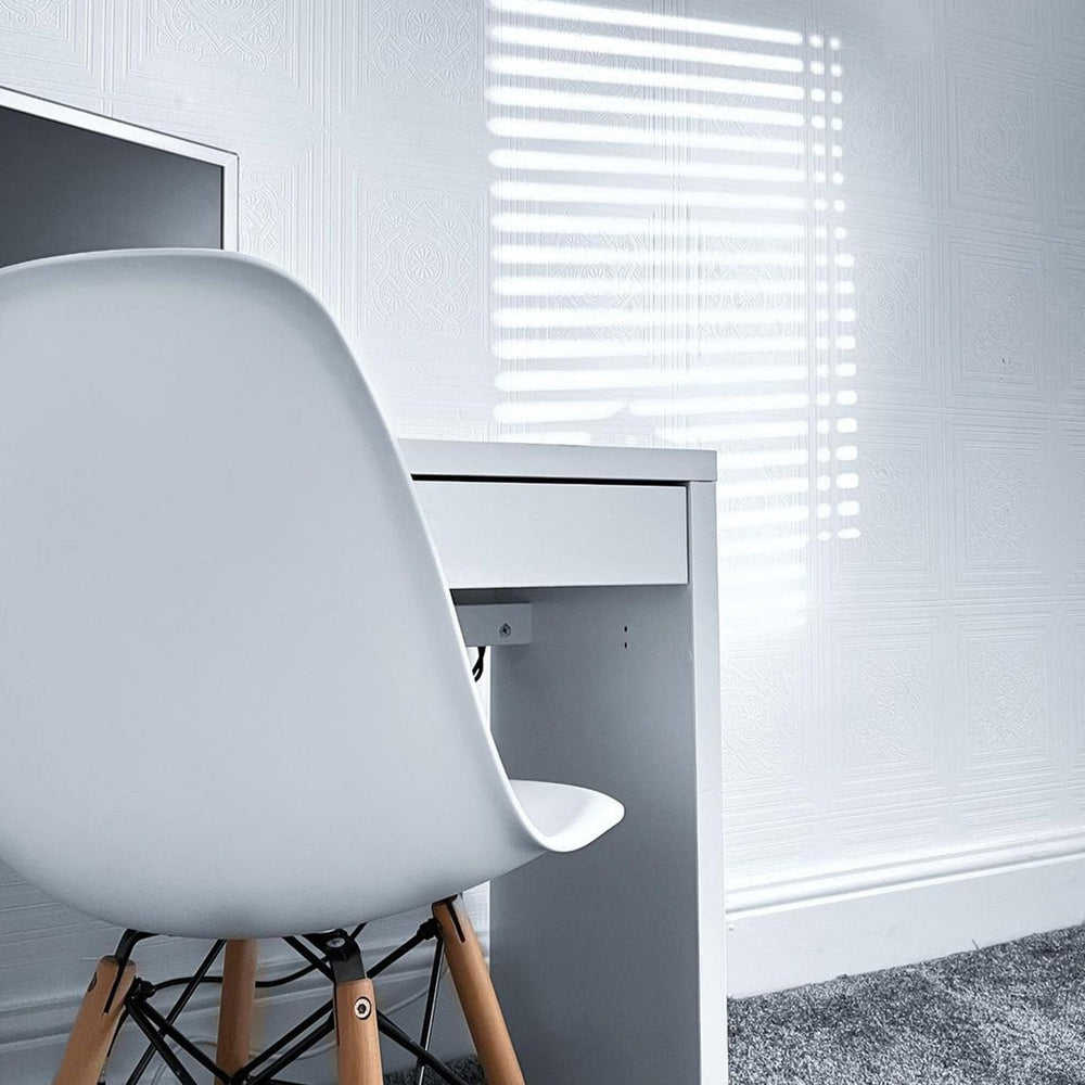 White moulded chair with wooden legs at a white desk