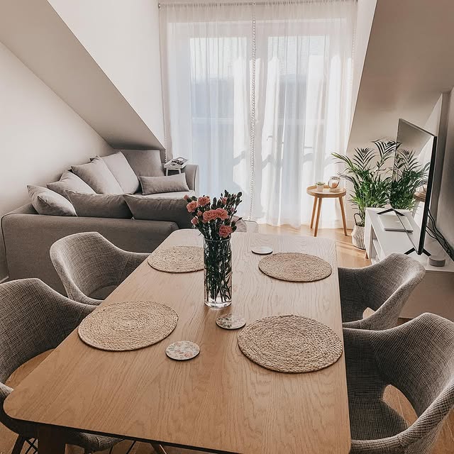 Grey Olivia fabric armchairs around an oak dining table in an open-plan living room